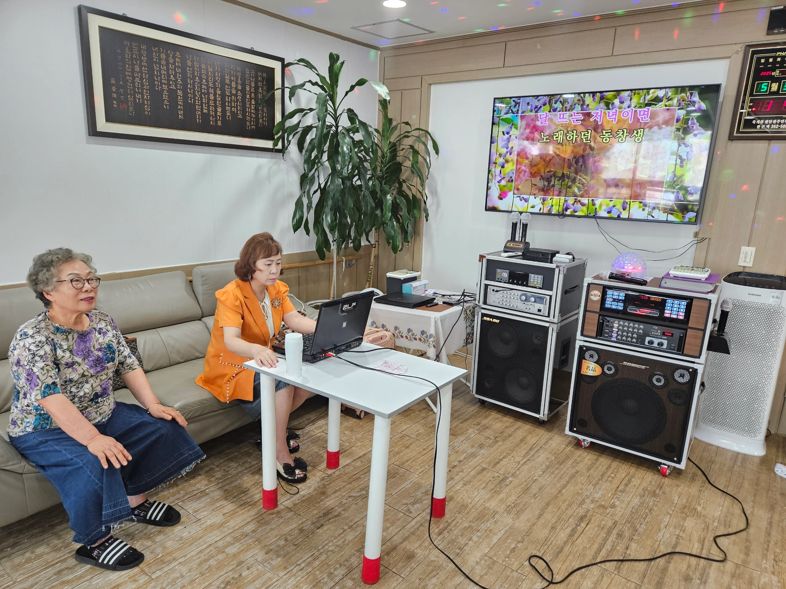 TV 노래방 화면과 마이크가 있는 영진요양원 노래 활동 공간